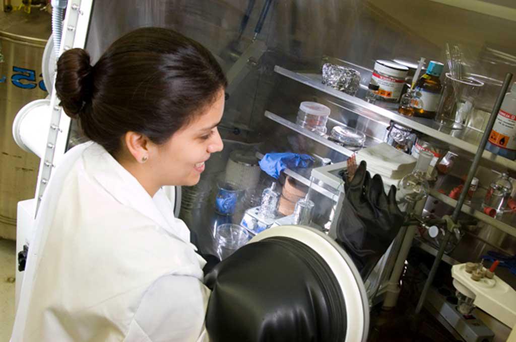 纳米技术研究所. 图中，身着白大褂的研究人员正通过手套操作一个实验装置.